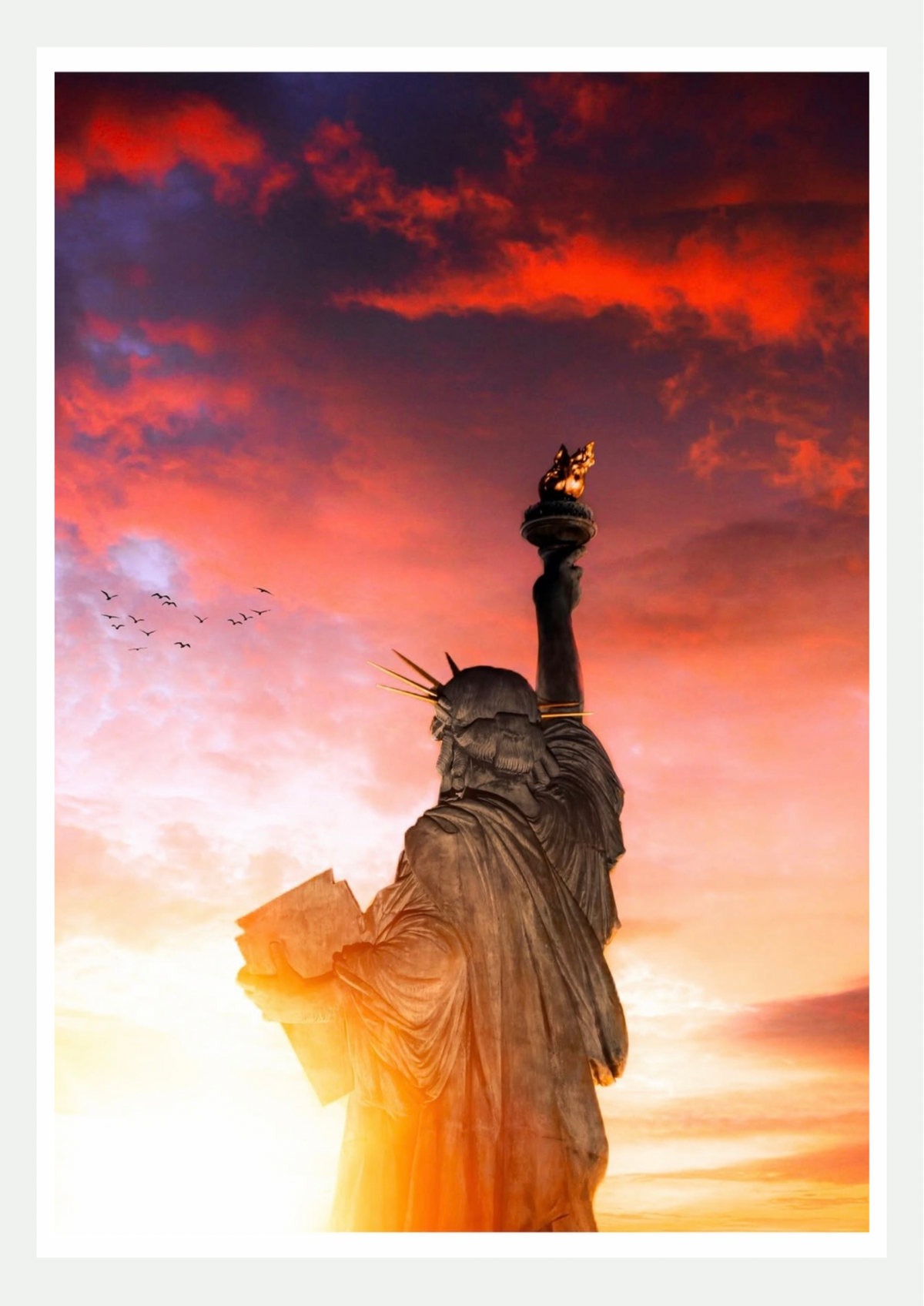 Affiche photo de la Statue de la Liberté vue de dos, torche dorée levée sous un ciel rouge et orange au coucher du soleil