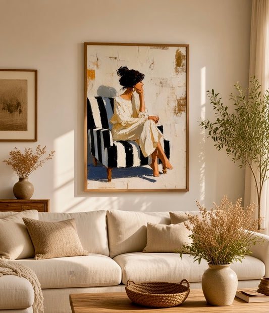 Affiche femme au fauteuil rayé noir et blanc encadrée, accrochée au mur d'un salon lumineux