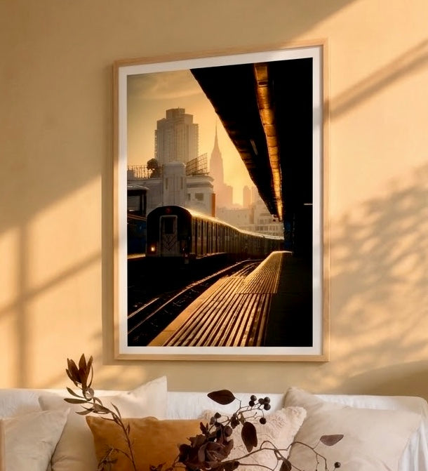 Gros plan sur la photo du métro de la ligne 7, reflets cuivrés sur le quai et silhouette de l'Empire State