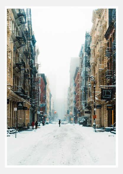 Affiche photo d'une rue de SoHo à New York sous la neige, façades en fonte et escaliers de secours, passant au parapluie au centre
